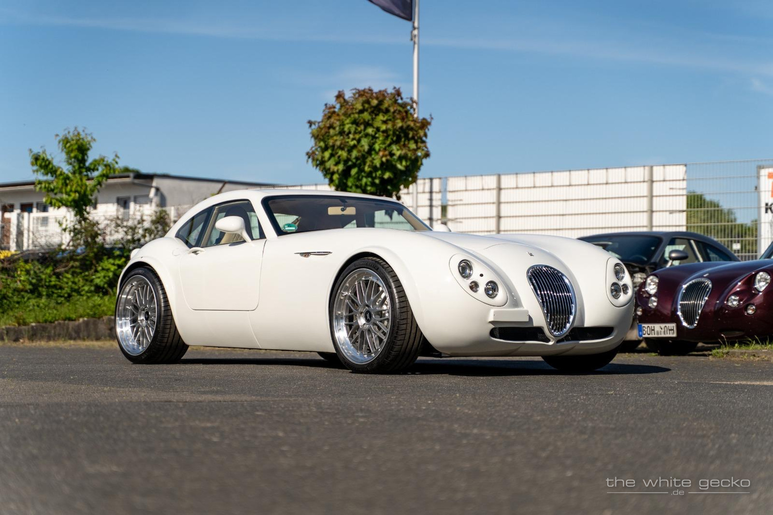 Weißer Wiesmann MF4 GT No.180 in tiefer Front-Dreiviertelansicht auf dem Hof