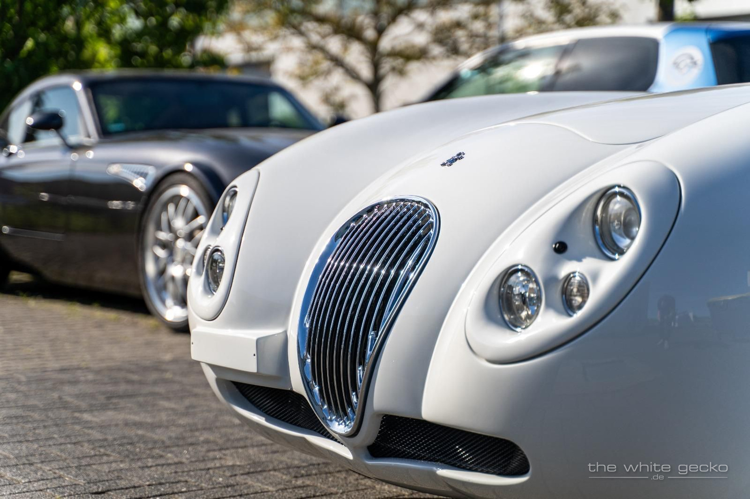 Frontpartie des weißen Wiesmann MF4 GT No.180 mit klassischem Chrom-Kühlergrill und einem weiteren Wiesmann im Hintergrund