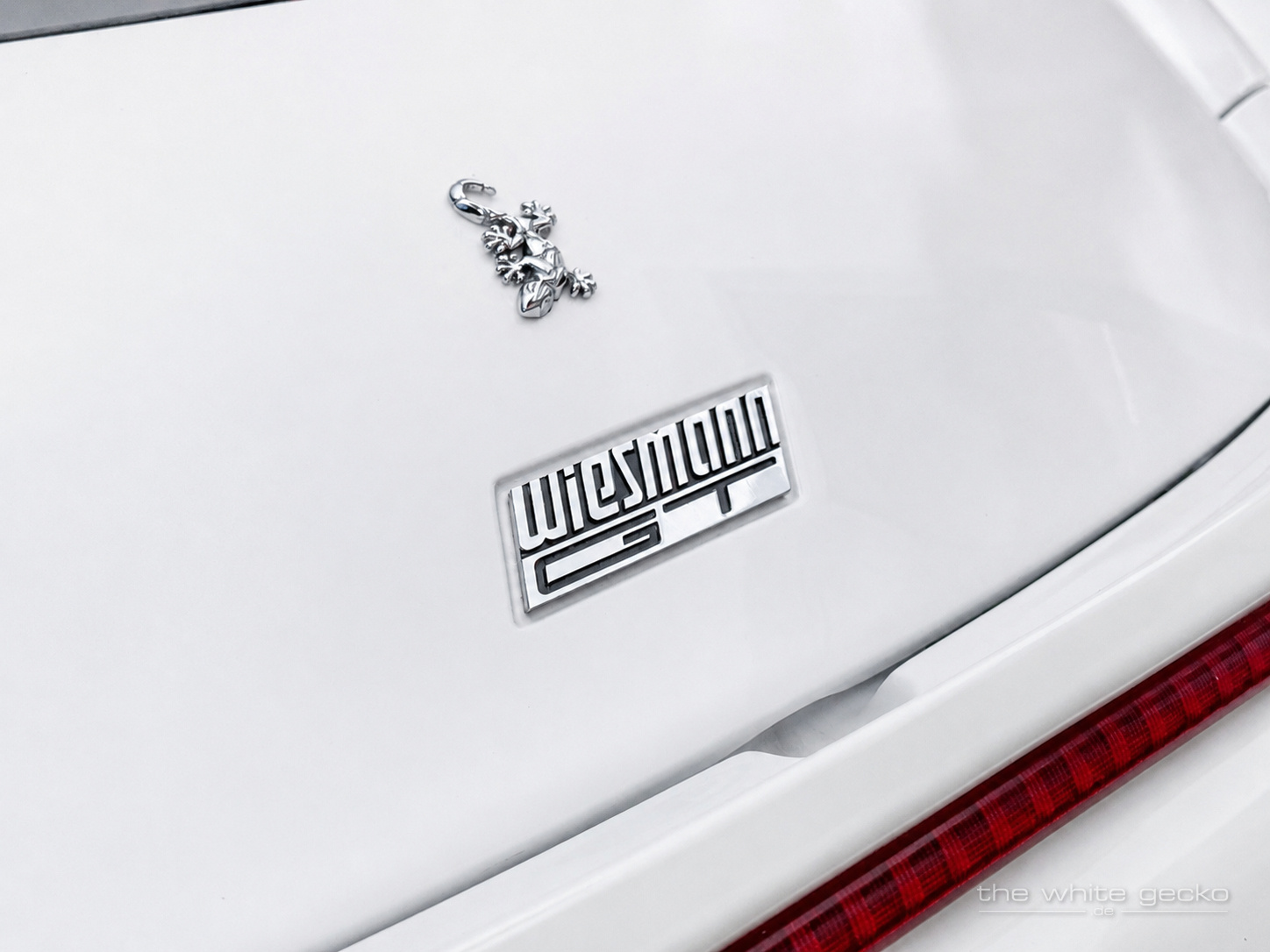 Nahaufnahme des Wiesmann-Geckos und des GT-Schriftzugs auf der weißen Karosserie des Wiesmann MF4 GT No.180