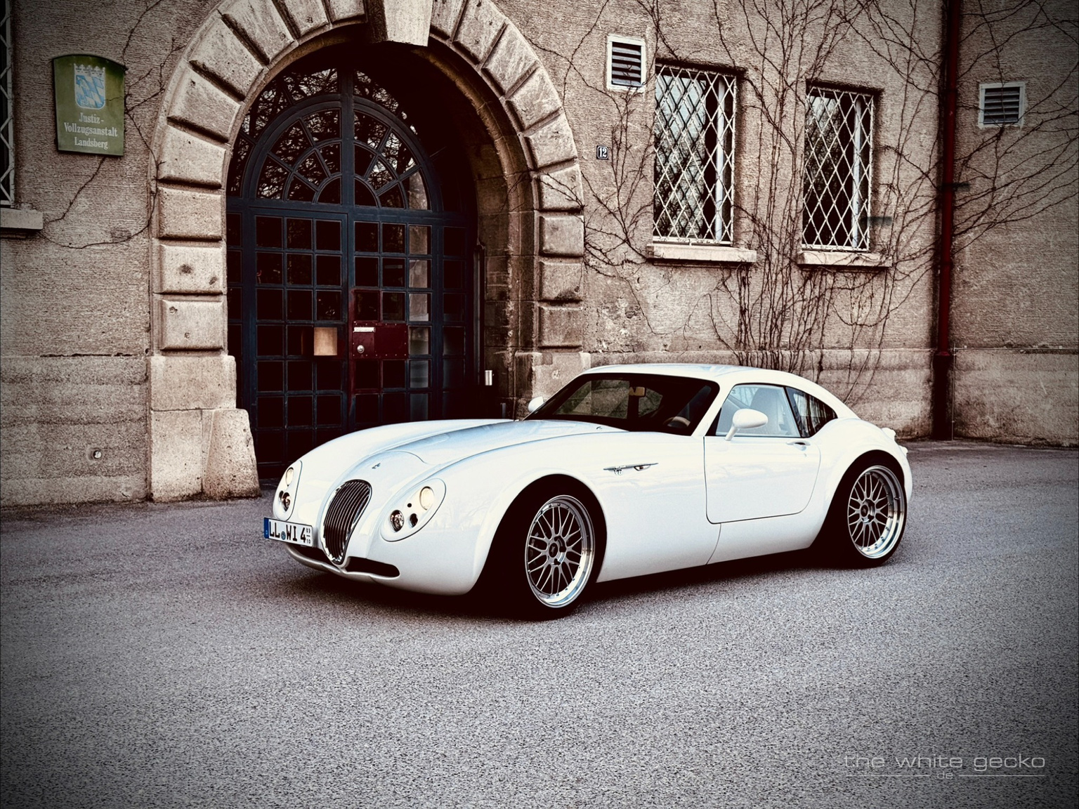 Weißer Wiesmann MF4 GT No.180 in Dreiviertelansicht vor dem historischen Gebäude des Gefängnisses in Landsberg