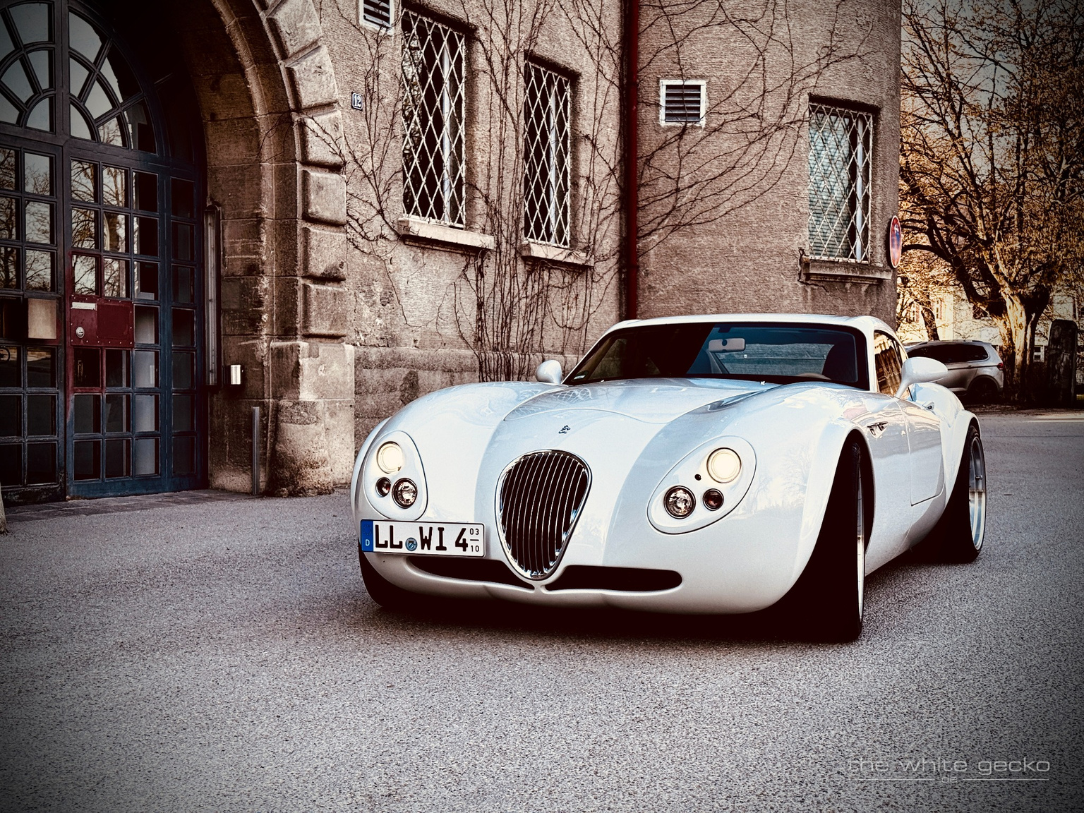 Frontaufnahme des weißen Wiesmann MF4 GT No.180 vor dem historischen Gebäude des Gefängnisses in Landsberg