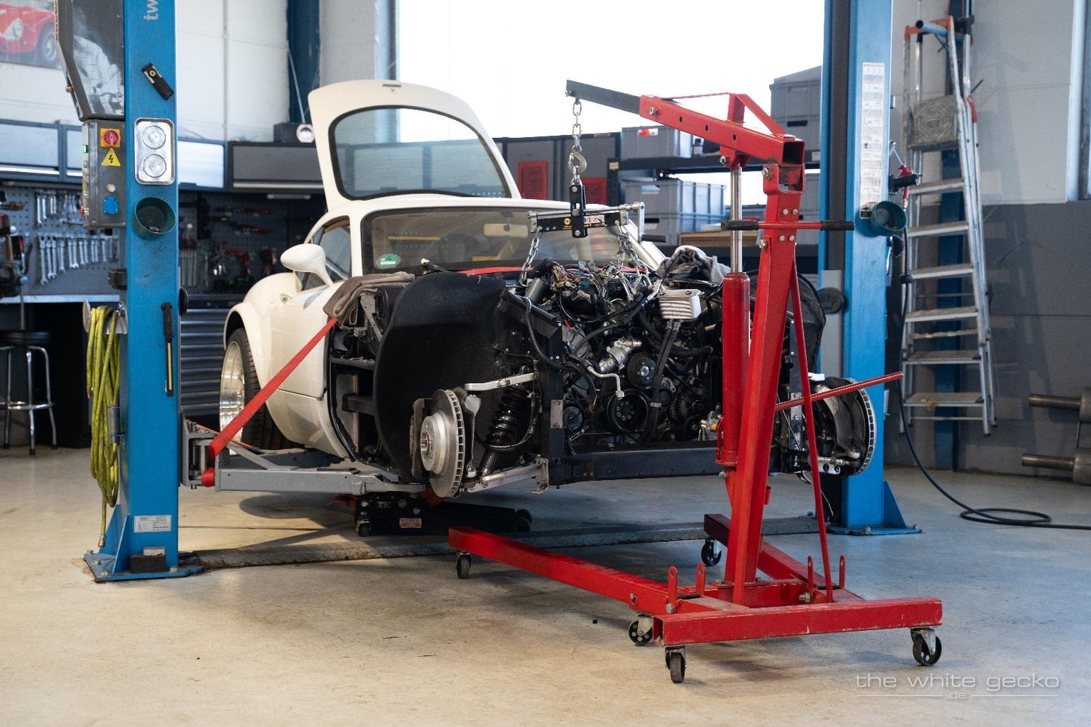 Wiesmann MF4 GT No.180 in der Werkstatt mit geöffnetem Vorderwagen und rotem Motorkran