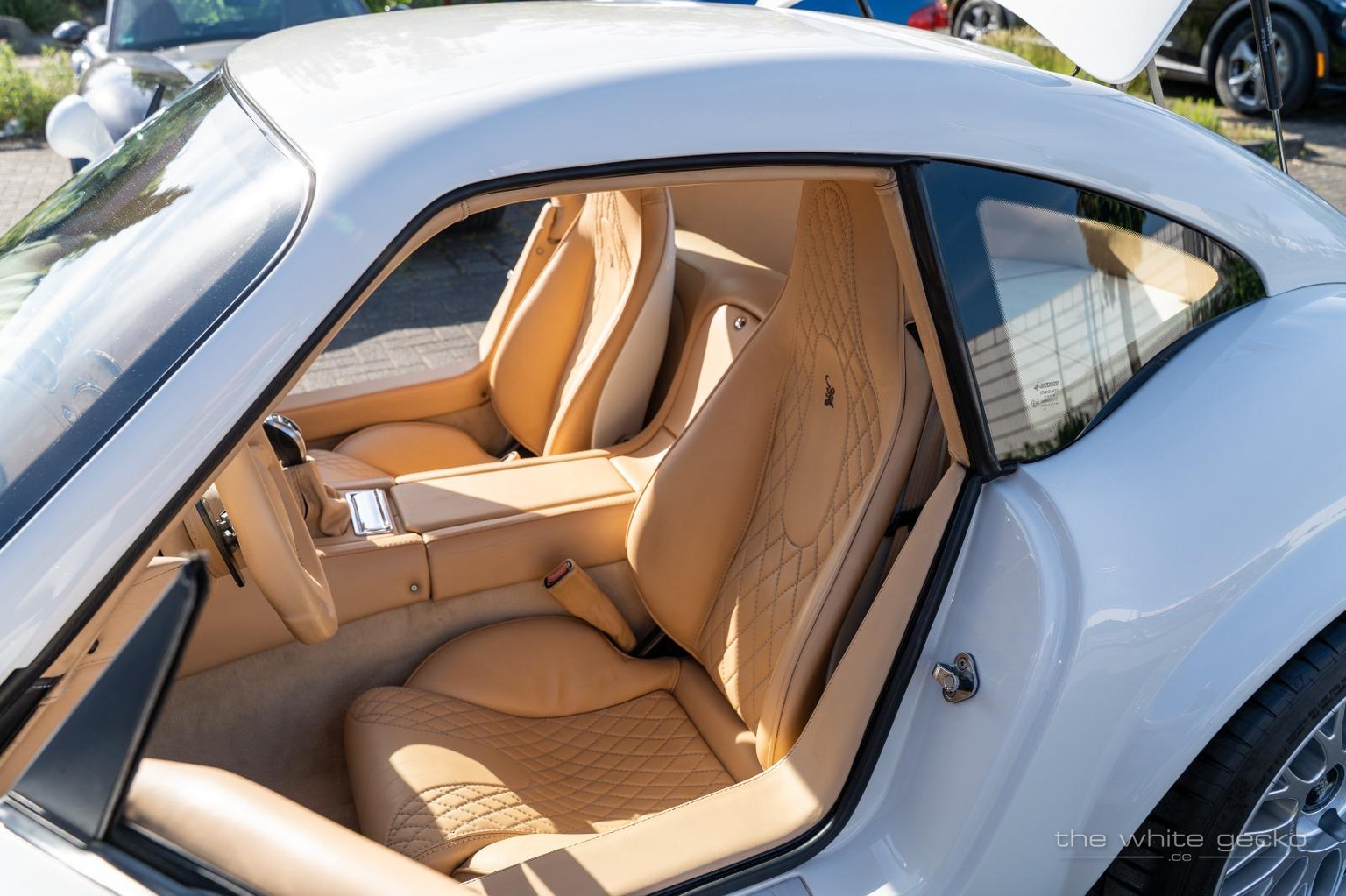 Blick durch die geöffnete Tür auf die cremefarbenen Sitze mit Rautensteppung und Gecko-Stickerei im Wiesmann MF4 GT No.180